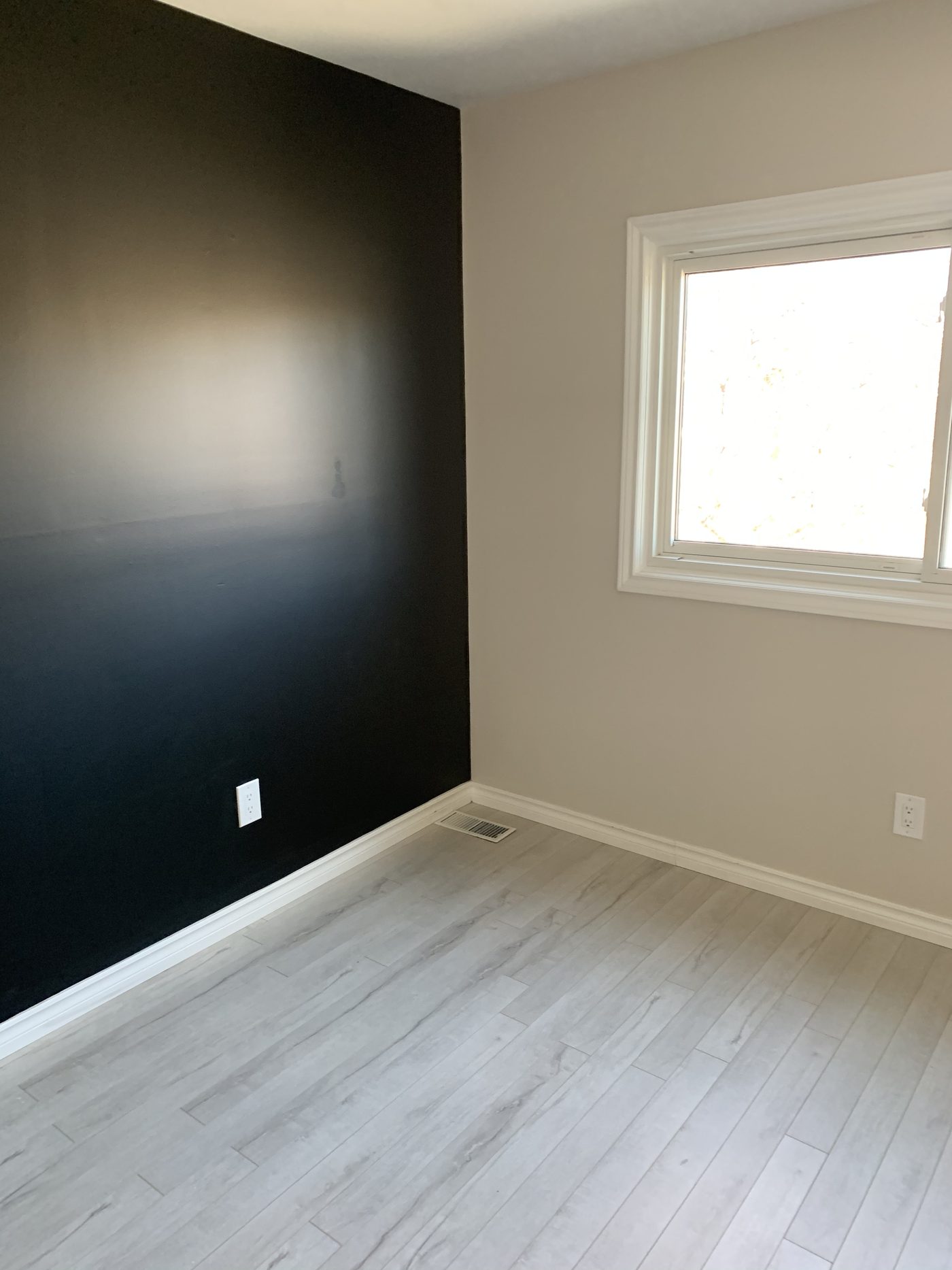 Painted room with dark feature wall and new flooring